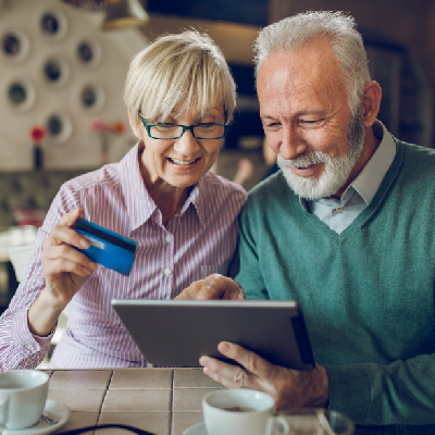 Senior couple making a purchase on their tablet with a credit card